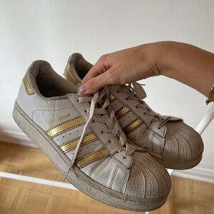 Distressed gold metallic adidas superstars
